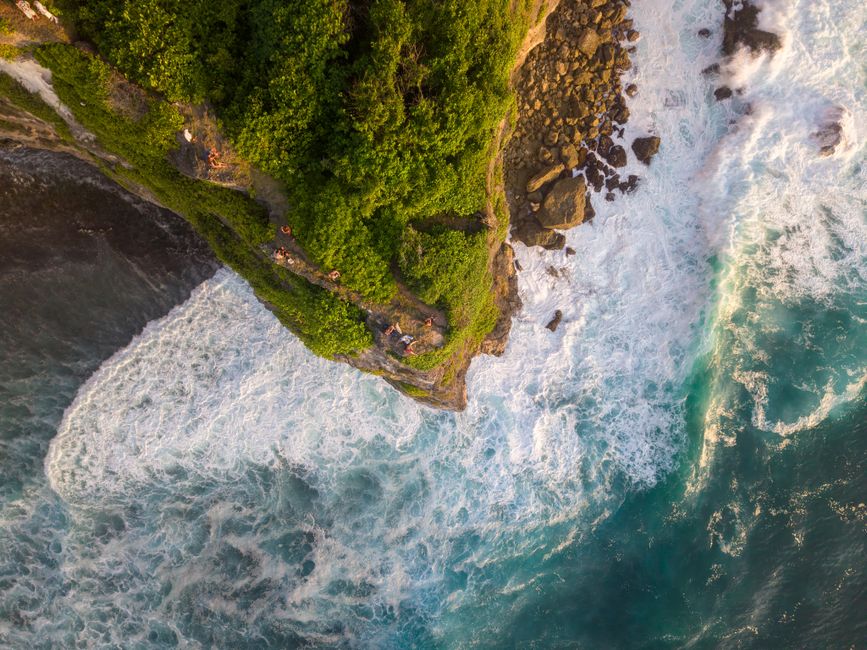 Stunning aerial shot of cliffs and ocean waves crashing in Bali, Indonesia.