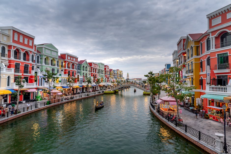 Scenic view of a colorful canal lined with vibrant buildings on an overcast day.
