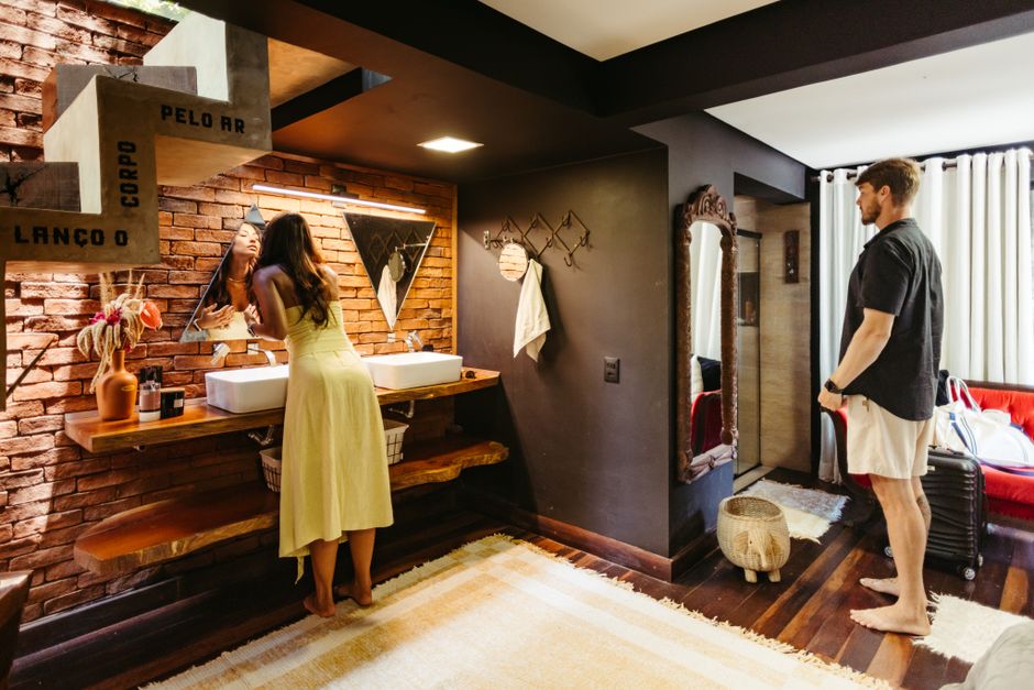 A couple in a stylish bathroom with brick wall and wooden decor.