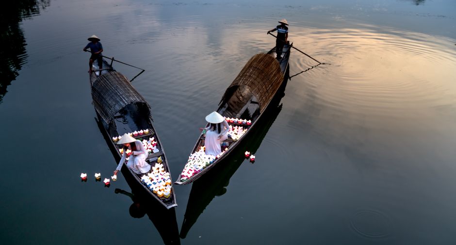 A tranquil scene of traditional boats with lanterns floating at dusk, reflecting cultural beauty.