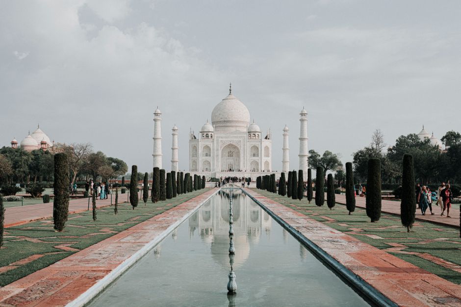 A serene and captivating perspective of the iconic Taj Mahal in Agra with reflection in pool.