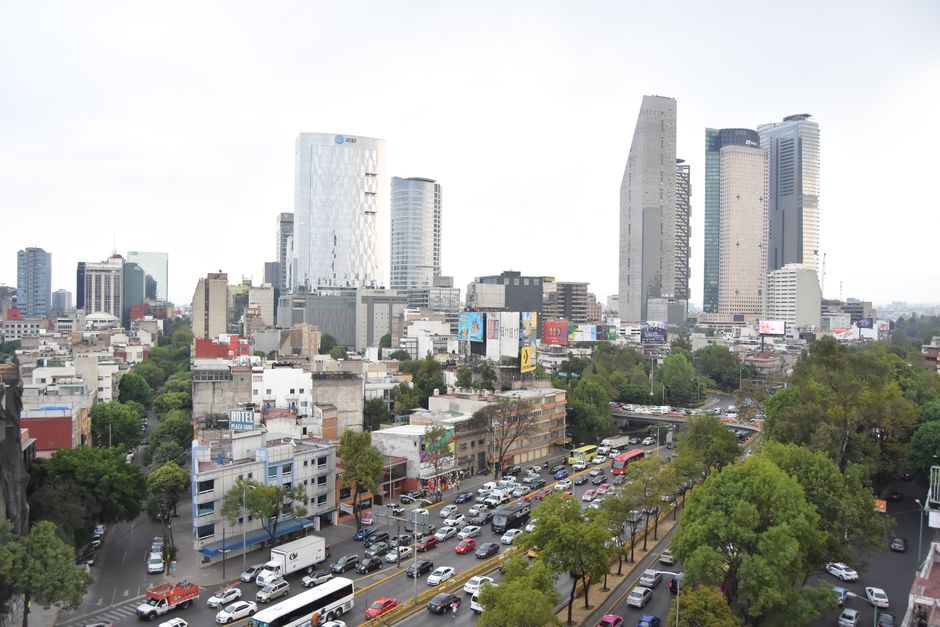 Mexico City street with skyscrapers and green trees on a dry January day