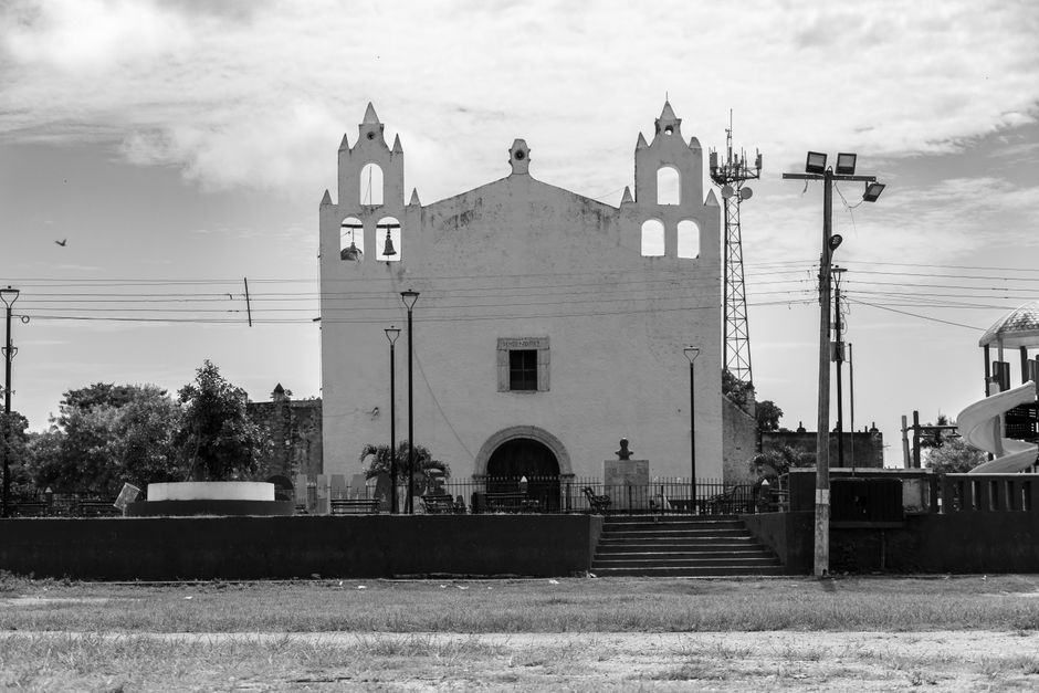Black and white image of a historic colonial church in Yucatán, showcasing traditional architecture.