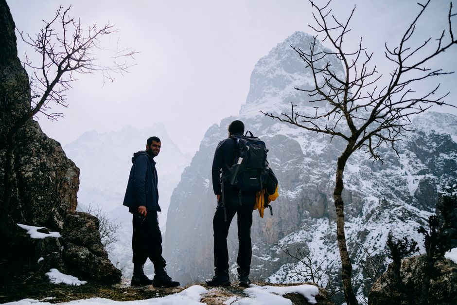 Two hikers exploring a snowy mountain landscape in winter, capturing the adventure and beauty of nature.